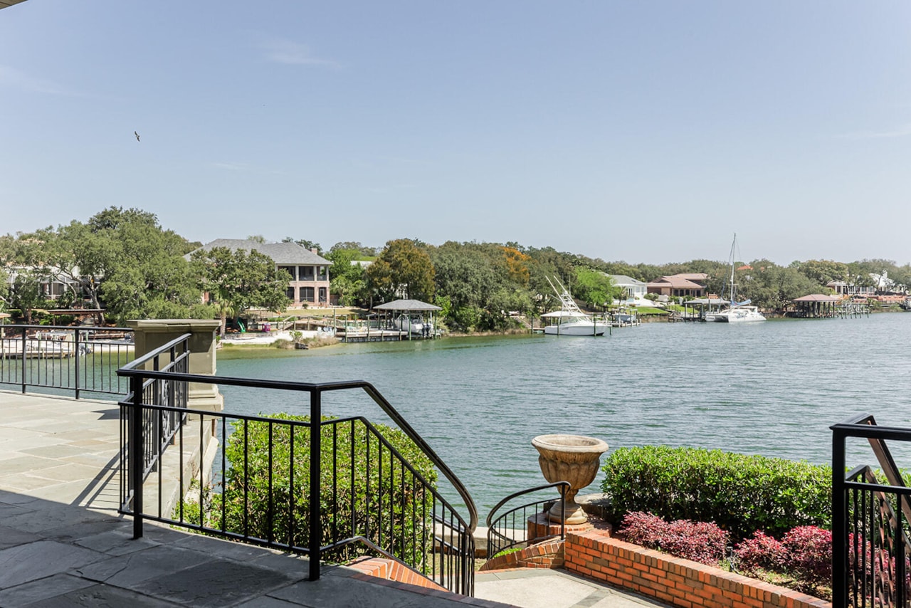 View from the bayfront patio looking west across the cove toward sailing boats and the wooded shoreline opposite